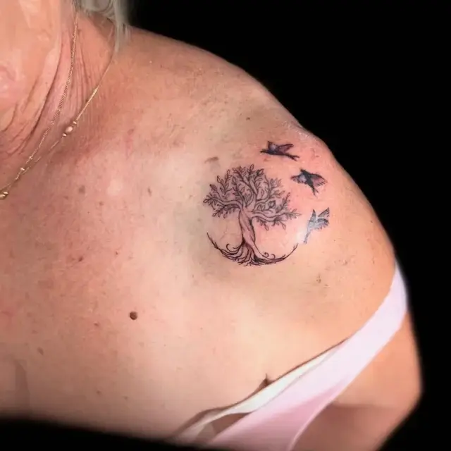 Tatuaje fine line de árbol de la vida con pájaros en el hombro