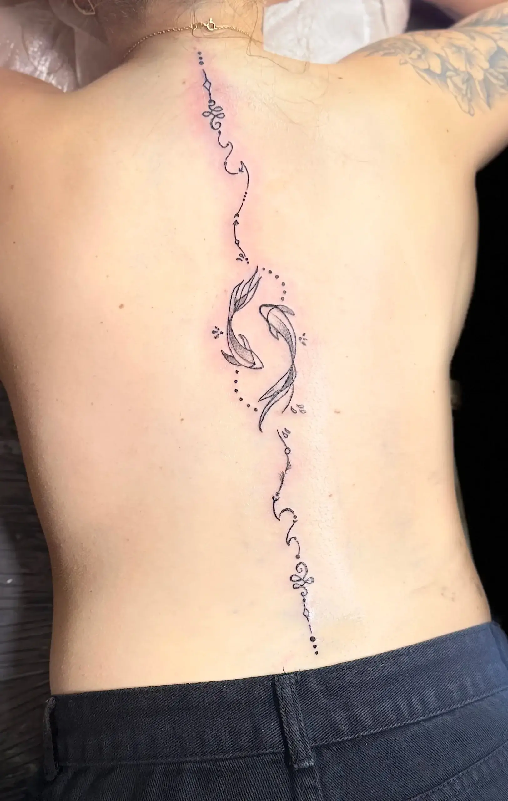 Tatuaje fine line a lo largo de la columna