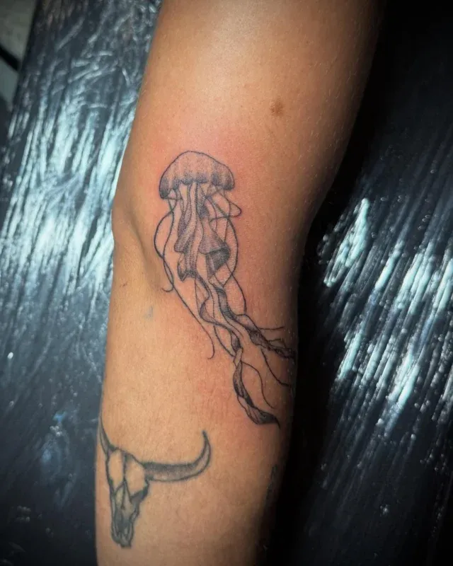 Tatuaje fine line de medusa en el antebrazo