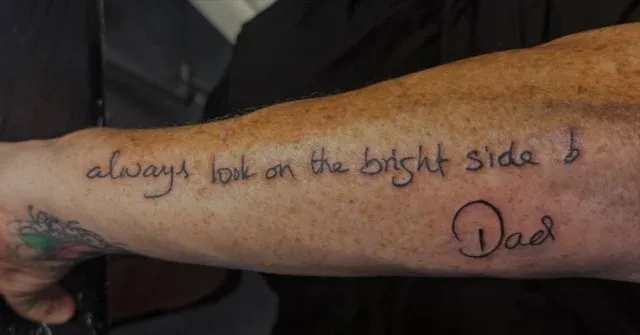 Tatuaje lettering de frase en inglés con firma en el antebrazo