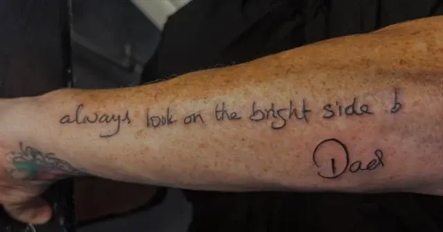 Tatuaje lettering de frase en inglés con firma en el antebrazo