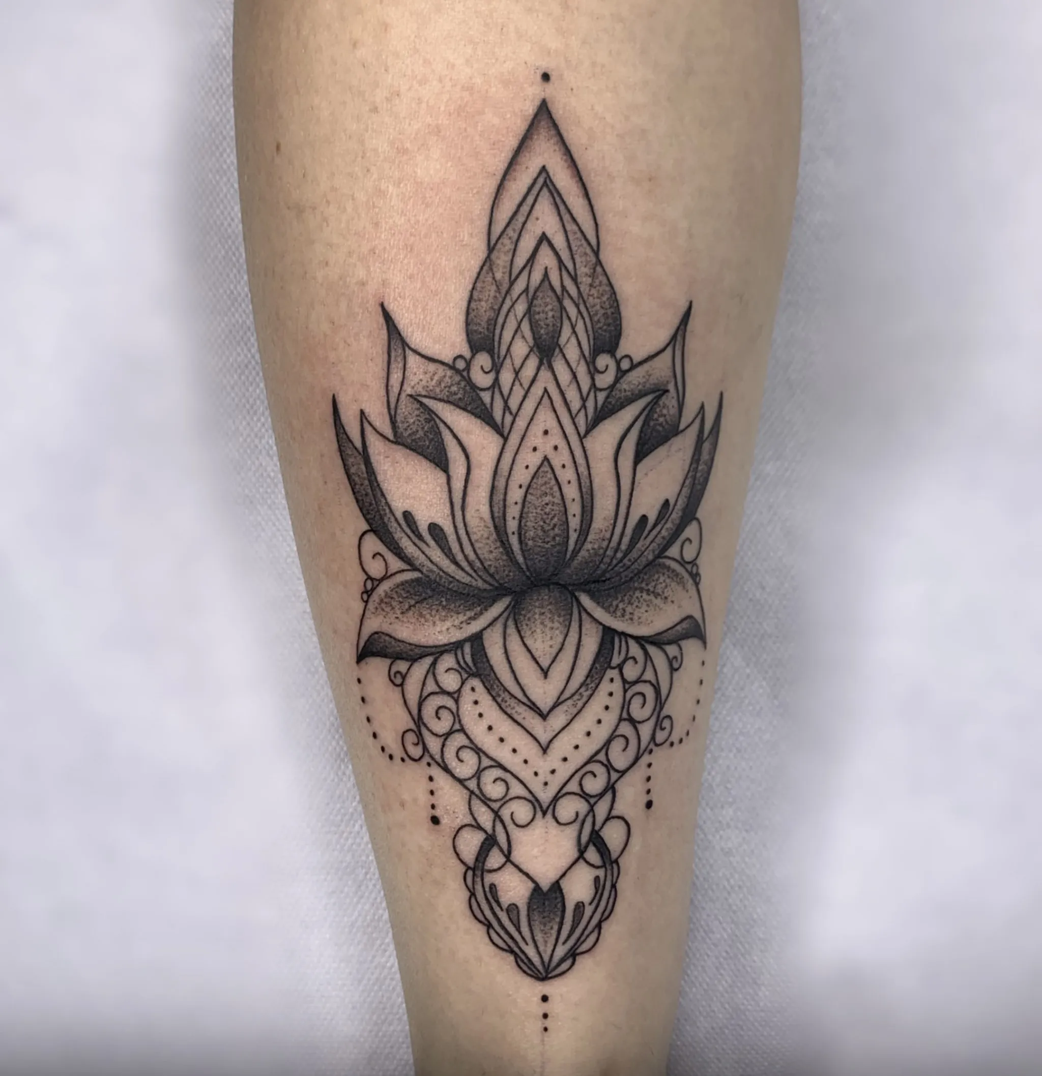 Tatuaje de mandala con flor de loto en el antebrazo