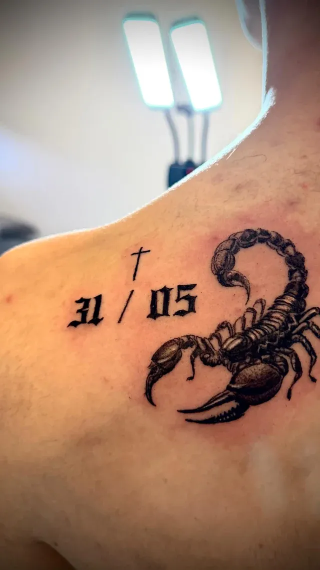 Tatuaje personalizado de escorpión con fecha en el hombro
