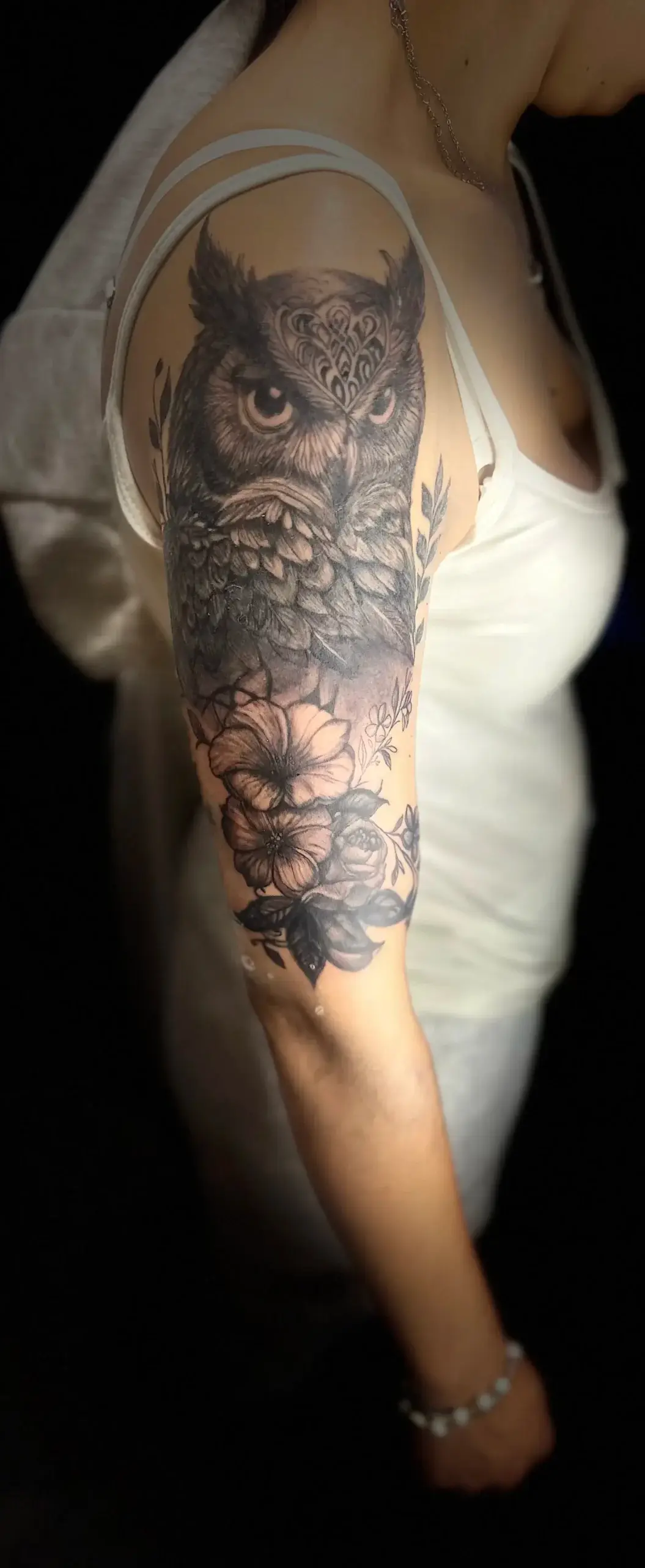 Tatuaje realista de búho en negro y gris en el brazo