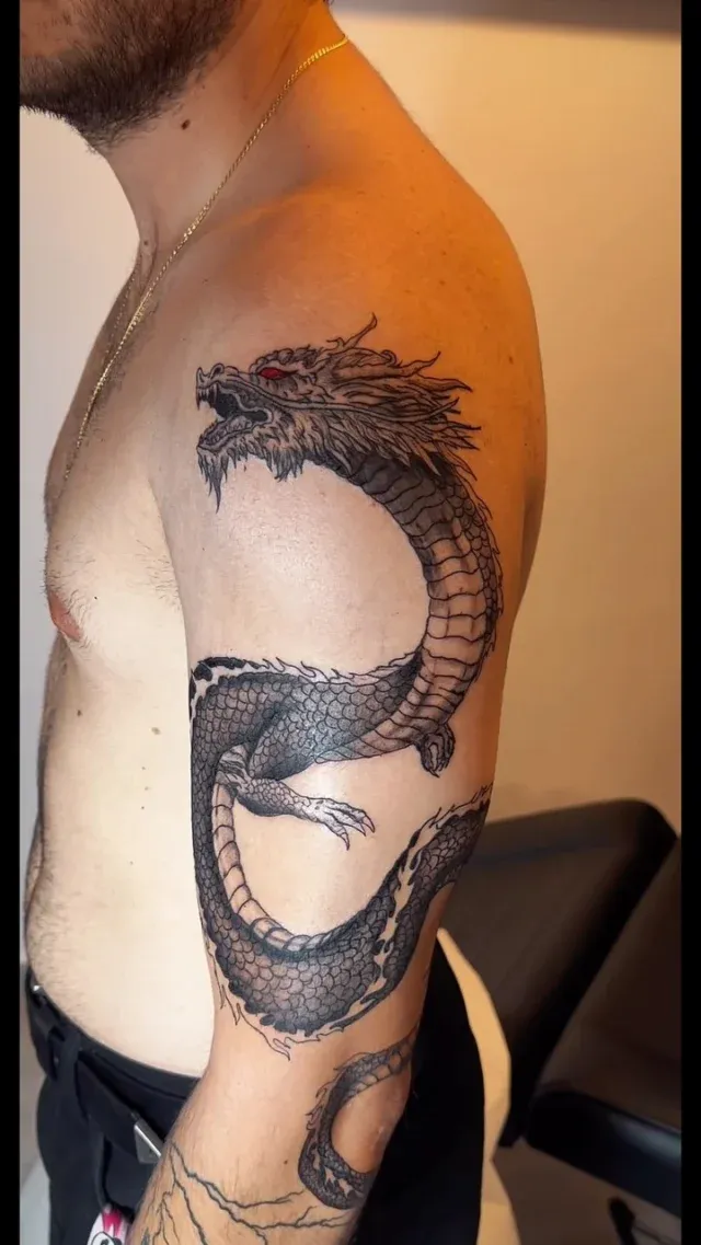 Tatuaje realista de dragón en el brazo